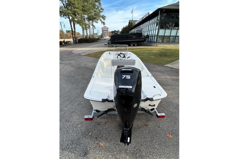 Slide: The Image of 2025 Mako Pro Skiff 17 CC with Mercury 75 engine, parked outdoors. - 2