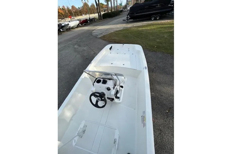 Slide: The Image of 2025 Mako Pro Skiff 17 CC boat with center console on display outdoors. - 5
