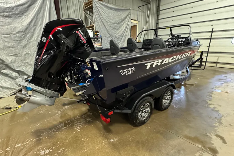 Slide: The Image of 2025 Tracker Targa V-19 WT boat in a garage, featuring a powerful outboard motor. - 3