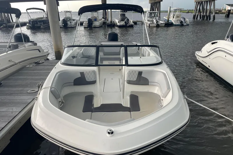Slide: The Image of 2023 Bayliner VR6 Bowrider OB docked at marina, featuring spacious seating and sleek design. - 1