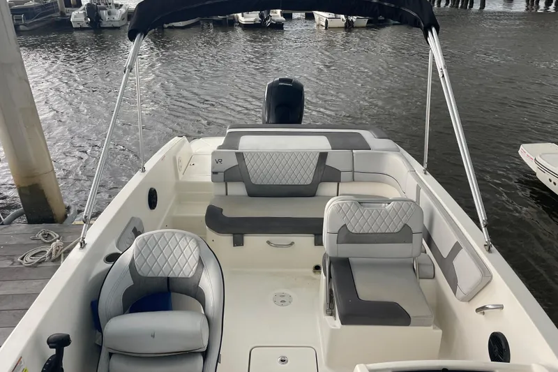 Slide: The Image of 2023 Bayliner VR6 Bowrider OB with spacious seating and modern design at a dock. - 6