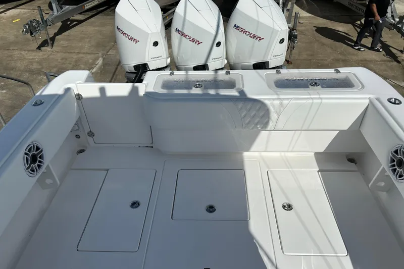 Slide: The Image of 2025 Contender 35 ST boat deck with Mercury engines, featuring storage compartments and speakers. - 12