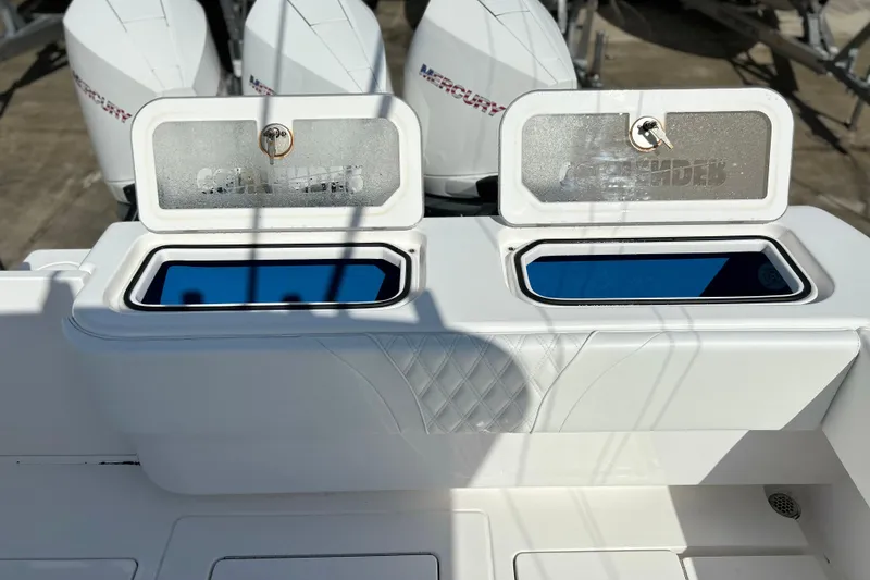 Slide: The Image of 2025 Contender 35 ST boat with open storage compartments and Mercury engines in the background. - 19