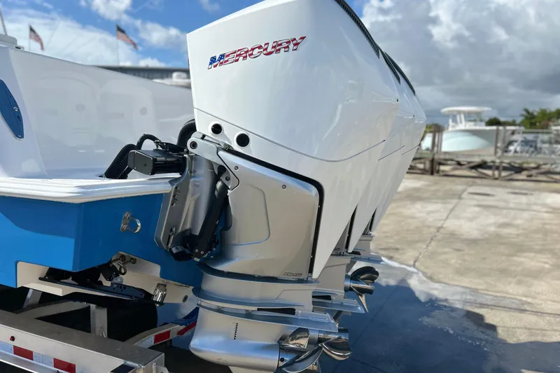 Slide: The Image of 2025 Contender 35 ST boat with Mercury outboard engines, docked under a cloudy sky. - 3