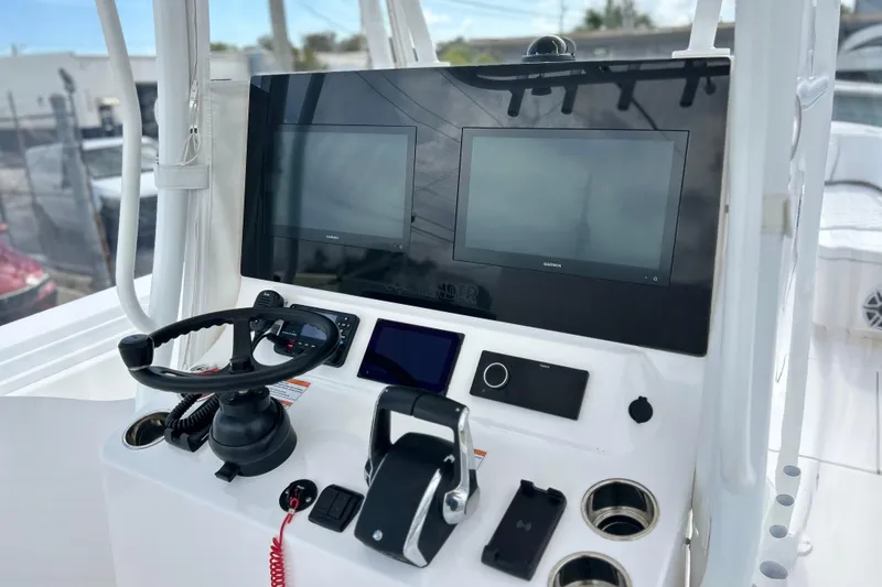 Slide: The Image of 2025 Contender 35 ST boat dashboard with dual screens and steering wheel. - 33