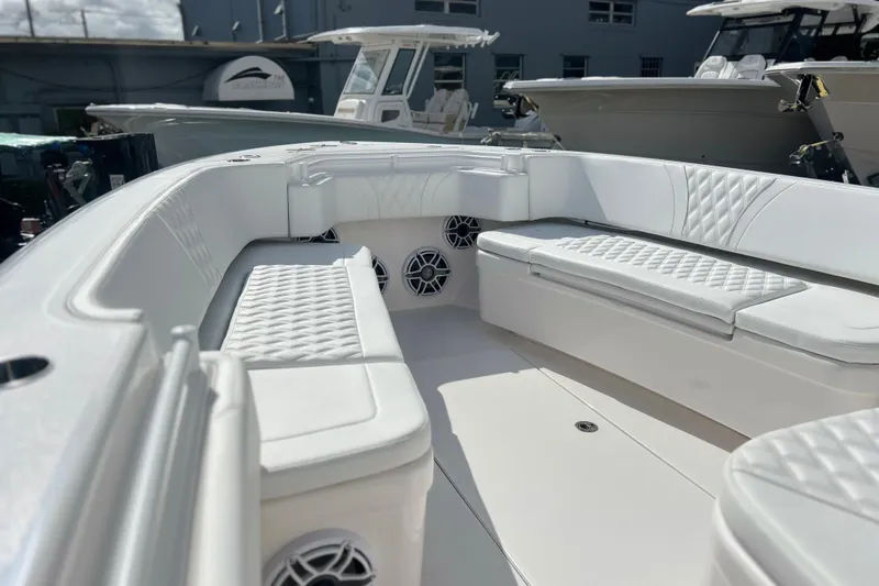 Slide: The Image of 2025 Contender 35 ST boat interior with white cushioned seating and speakers. - 41