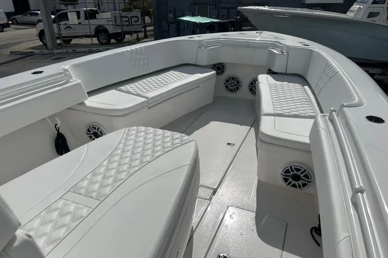 Slide: The Image of 2025 Contender 35 ST boat interior with white cushioned seating and speaker system. - 44