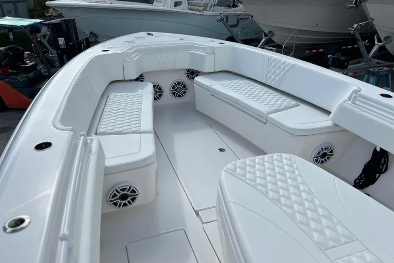 Slide: The Image of 2025 Contender 35 ST boat interior with white cushioned seating and speakers. - 50