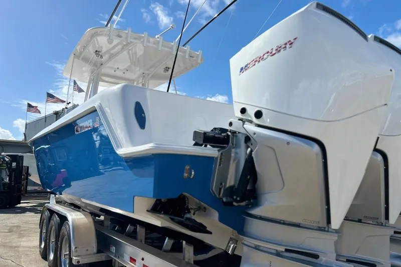 Slide: The Image of 2025 Contender 35 ST boat with Mercury engines on a trailer, under a clear blue sky. - 8