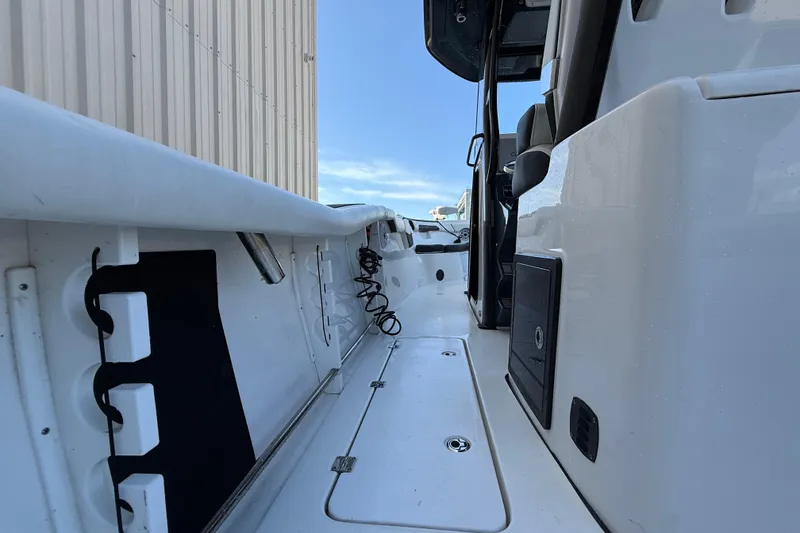 Slide: The Image of 2022 Tidewater 292 CC Adventure boat with dual 300 horsepower engines, docked near a warehouse. - 13