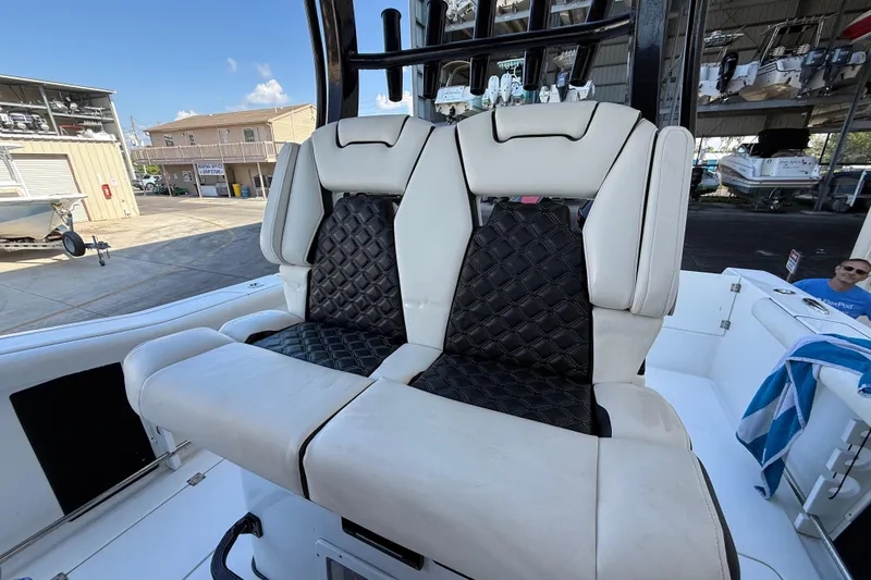 Slide: The Image of 2022 Tidewater 292 CC Adventure boat with twin outboard engines, docked outdoors. - 14