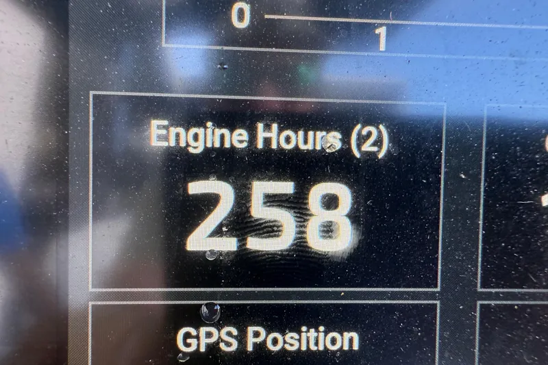 Slide: The Image of 2022 Tidewater 292 CC Adventure boat interior with seating and speakers, docked near waterfront homes. - 28