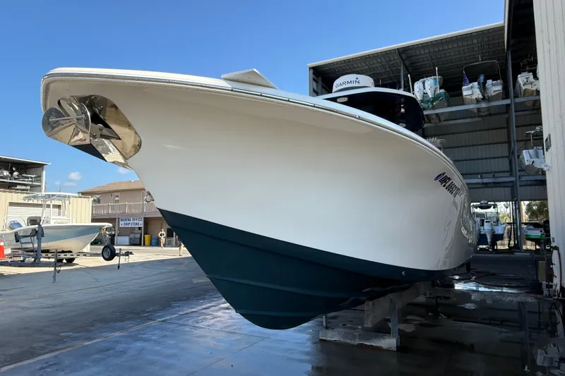 Slide: The Image of 2022 Tidewater 292 CC Adventure boat on clear, shallow water under blue sky. - 3