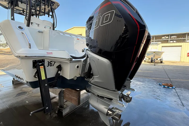 Slide: The Image of 2022 Tidewater 292 CC Adventure boat with powerful outboard engine in a marina setting. - 49