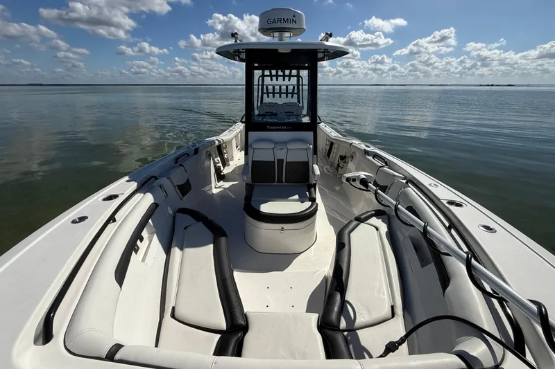 Slide: The Image of 2022 Tidewater 292 CC Adventure boat on calm water under a cloudy sky. - 57