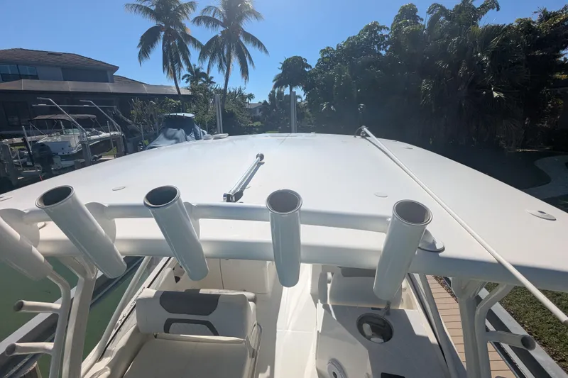Slide: The Image of 2021 World Cat 280 DC-X boat with rod holders, docked near palm trees. - 16