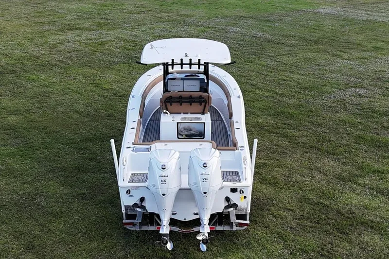 Slide: The Image of 2023 Seahunt 30 GameFish Coffin Box boat on grass, rear view with twin engines. - 12