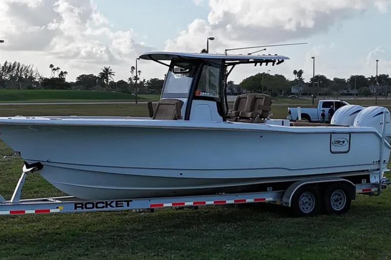 Slide: The Image of 2023 Seahunt 30 GameFish Coffin Box boat on trailer, parked on grass. - 3