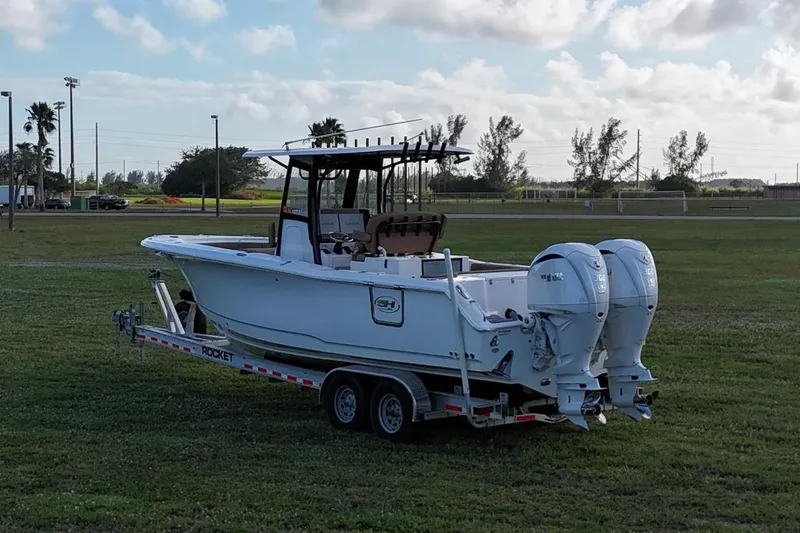 Slide: The Image of 2023 Seahunt 30 GameFish Coffin Box boat on trailer in grassy field. - 4