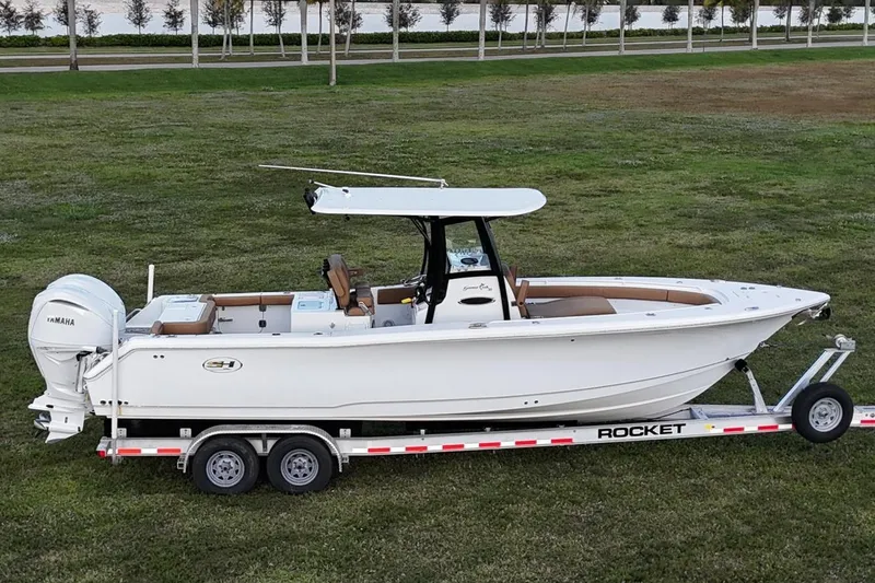 Slide: The Image of 2023 Seahunt 30 GameFish Coffin Box boat on trailer, parked on grass. - 5