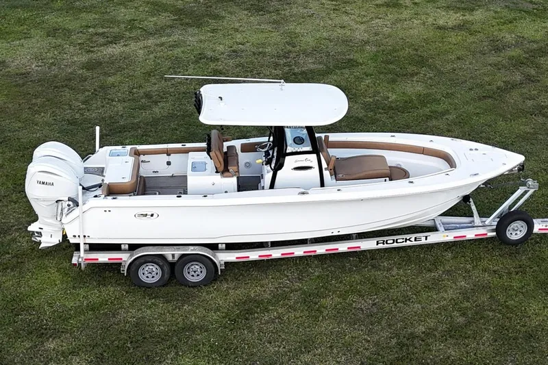Slide: The Image of 2023 Seahunt 30 GameFish Coffin Box boat on trailer, side view on grass. - 6
