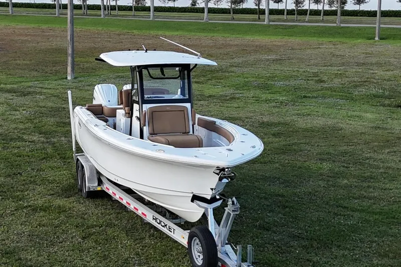 Slide: The Image of 2023 Seahunt 30 GameFish Coffin Box boat on trailer, parked on grass. - 8