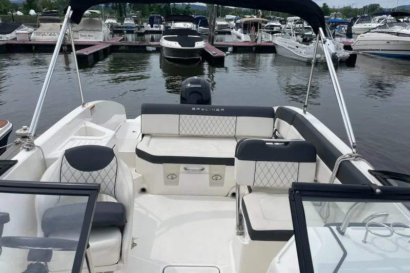 Slide: The Image of 2023 Bayliner DX 2200 boat interior at marina, featuring sleek seating and modern design. - 6
