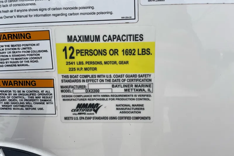 Slide: The Image of 2023 Bayliner DX 2200 capacity label: 12 persons or 1692 lbs, 225 HP motor. - 7
