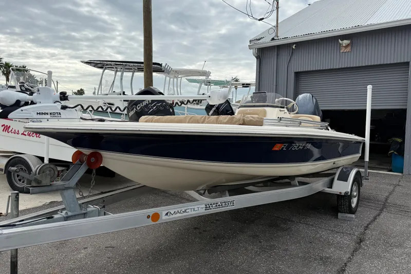 The Image of 2022 Scout 177 Sport boat on trailer, parked near a garage. - 0