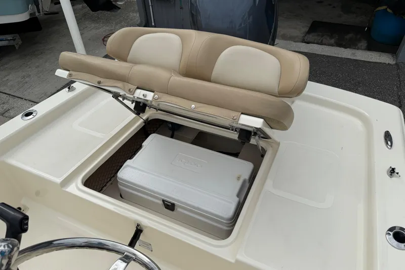 Slide: The Image of 2022 Scout 177 Sport boat with open storage compartment and cushioned seating. - 12