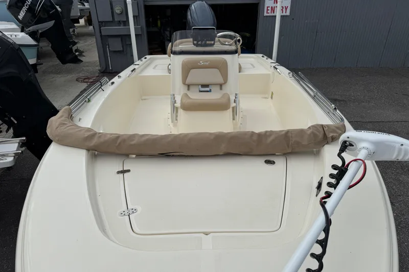Slide: The Image of 2022 Scout 177 Sport boat with beige seating and covered equipment on deck. - 6