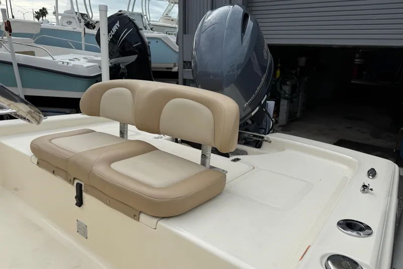Slide: The Image of 2022 Scout 177 Sport boat with beige seating and outboard motor in a marina. - 8