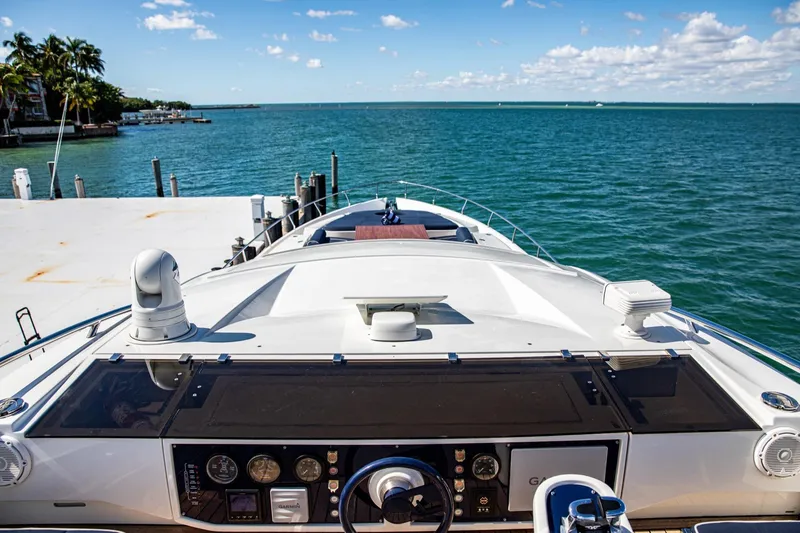 Slide: The Image of 2012 Pershing Sport Boat Planning docked by the ocean, clear sky, and palm trees. - 21