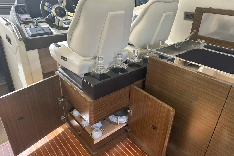 Slide: The Image of 2015 Azimut 55S yacht interior with helm, white seats, and wooden cabinetry. - 13