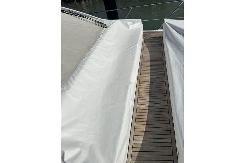 Slide: The Image of 2015 Azimut 55S yacht deck with white covers and wooden flooring. - 31