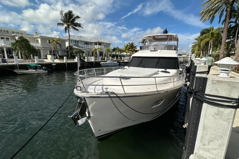 Slide: The Image of Luxury 2023 Belize 54 Day Bridge yacht docked by waterfront homes. - 3