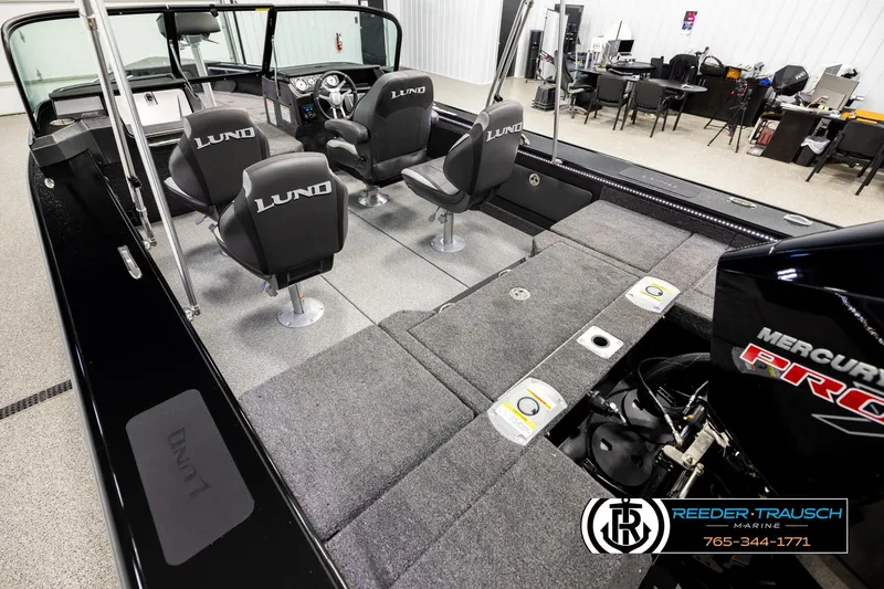 Slide: The Image of 2026 Lund 1975 Pro-V Sport boat interior with seating and Mercury engine, displayed at Reeder-Trausch Marine. - 10