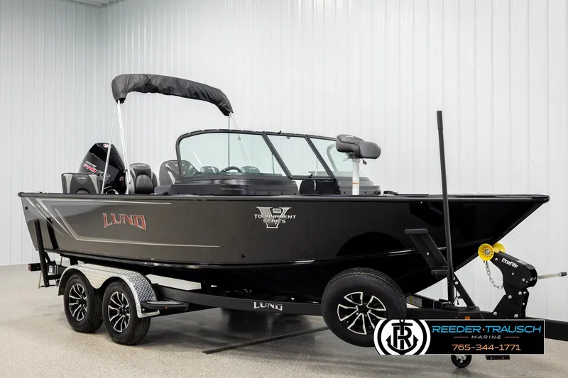 Slide: The Image of 2026 Lund 1975 Pro-V Sport boat on trailer in showroom, black exterior. - 2