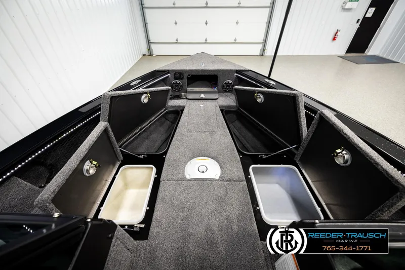 Slide: The Image of 2026 Lund 1975 Pro-V Sport boat interior with open storage compartments in a garage. - 23