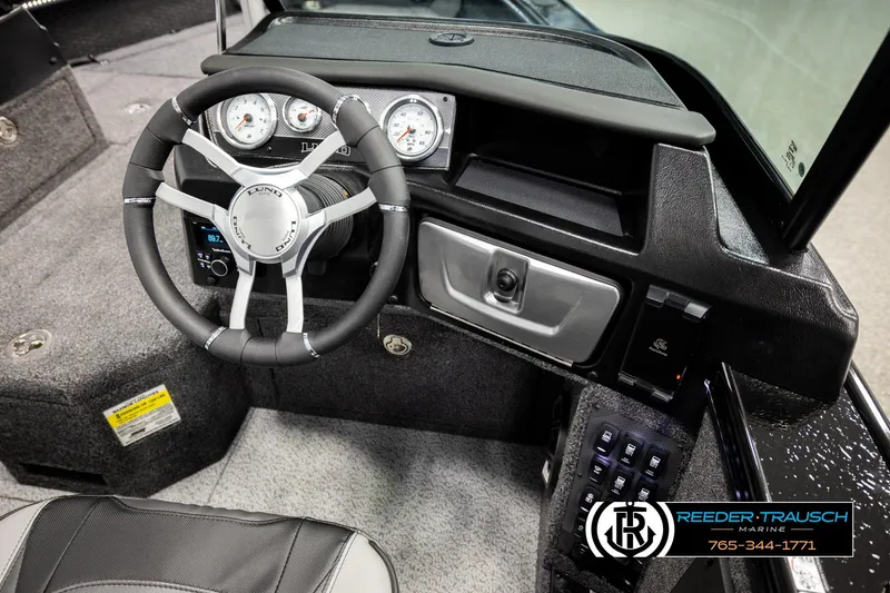 Slide: The Image of Interior of 2026 Lund 1975 Pro-V Sport boat, featuring steering wheel and dashboard controls. - 36