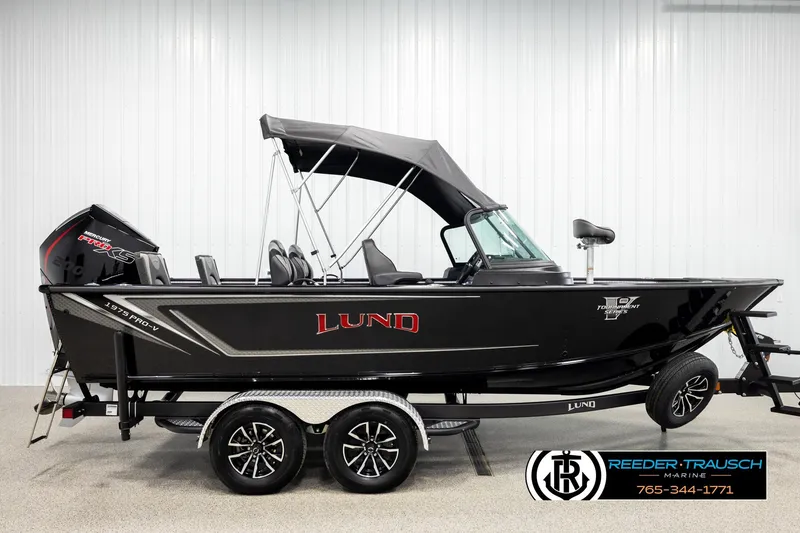 Slide: The Image of 2026 Lund 1975 Pro-V Sport boat with black exterior and canopy on a trailer. - 4