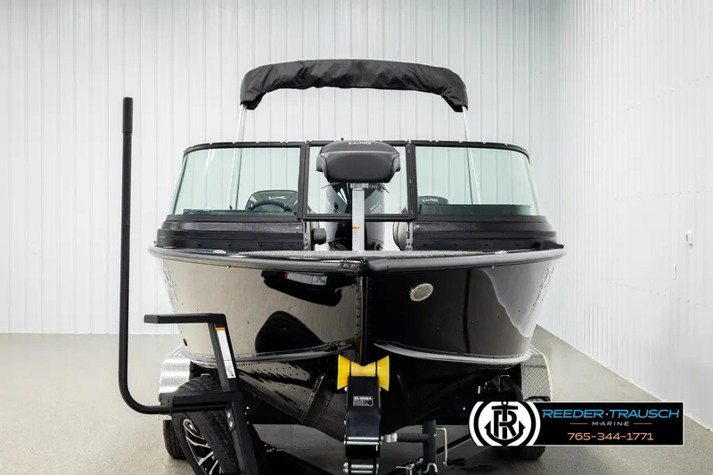 Slide: The Image of 2026 Lund 1975 Pro-V Sport boat in showroom, front view, black exterior. - 7