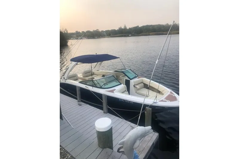 The Image of 2019 Regal LS6 boat docked on a serene lake with a canopy. - 0