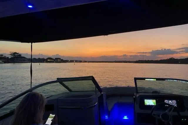 Slide: The Image of 2019 Regal LS6 boat at sunset, interior view with blue lights and scenic water. - 3