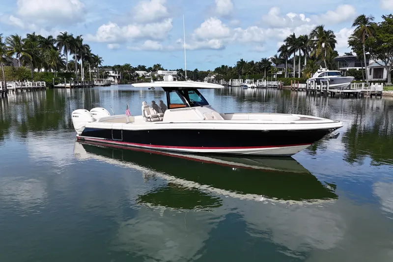 The Image of 2020 Chris-Craft Catalina 34 boat on a serene waterway with palm trees. - 0