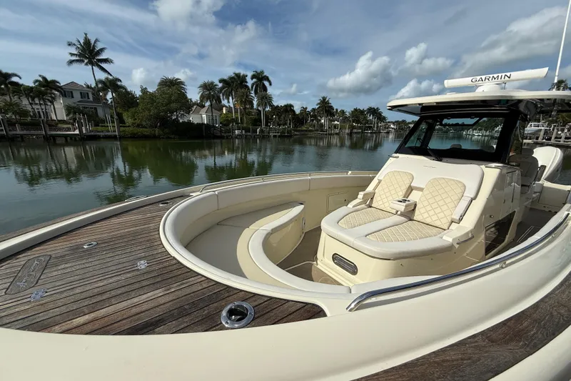 Slide: The Image of 2020 Chris-Craft Catalina 34 boat with luxurious seating, docked by a scenic waterfront. - 14