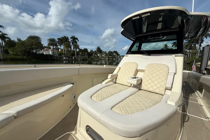 Slide: The Image of 2020 Chris-Craft Catalina 34 boat with luxurious seating, docked near palm trees. - 16