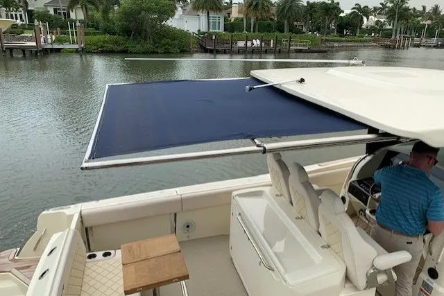 Slide: The Image of 2020 Chris-Craft Catalina 34 boat with extended sunshade, docked by a scenic waterfront. - 28