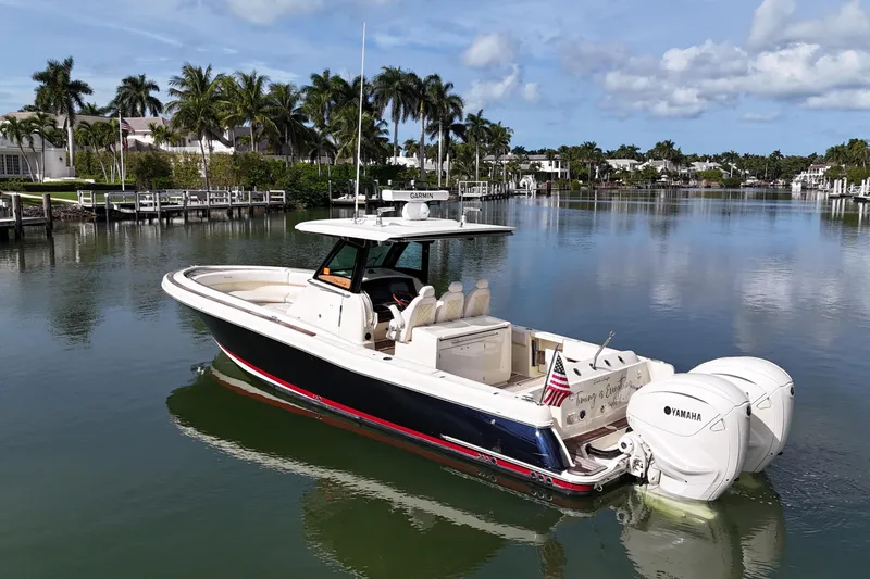 Slide: The Image of 2020 Chris-Craft Catalina 34 boat on calm water, surrounded by palm trees and luxury homes. - 9