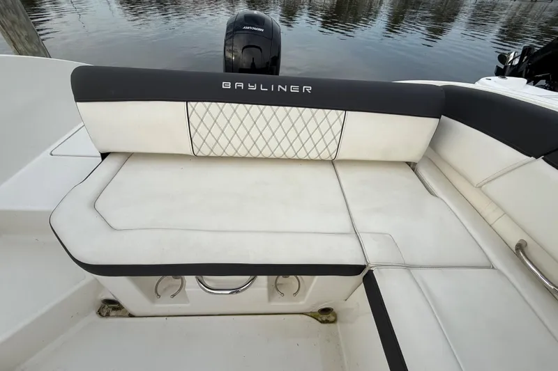 Slide: The Image of 2023 Bayliner DX 2200 boat seating with diamond-patterned upholstery and Mercury outboard motor. - 11